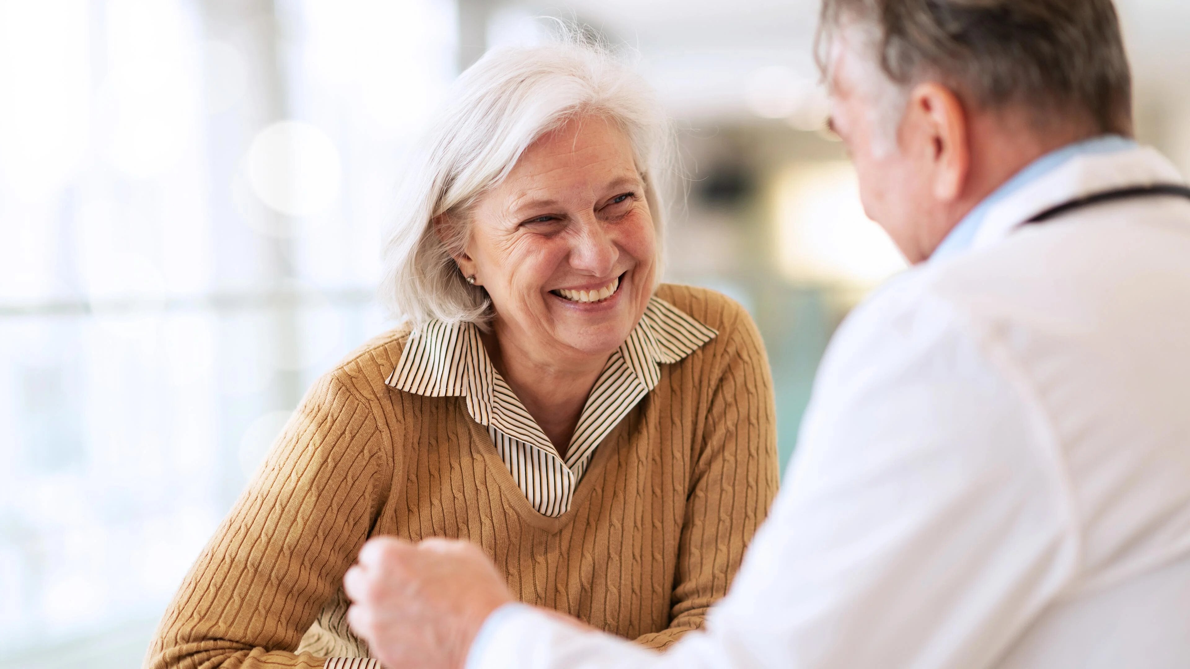 An Image of an old lady sitting with a health care professional discussing about Dysphagia