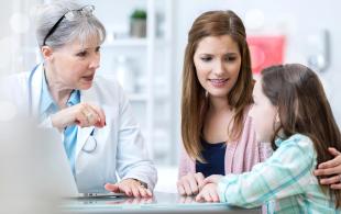 An Image of health care professional siting with a mother and her child discussing about Cystic Fibrosis