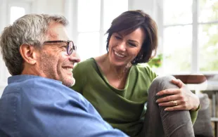 An Image of a man sitting next to a woman on a couch